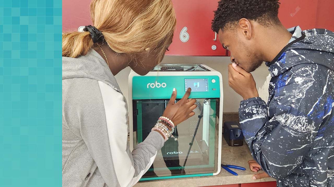 Two high school students tapping screen on Robo 3D printer.